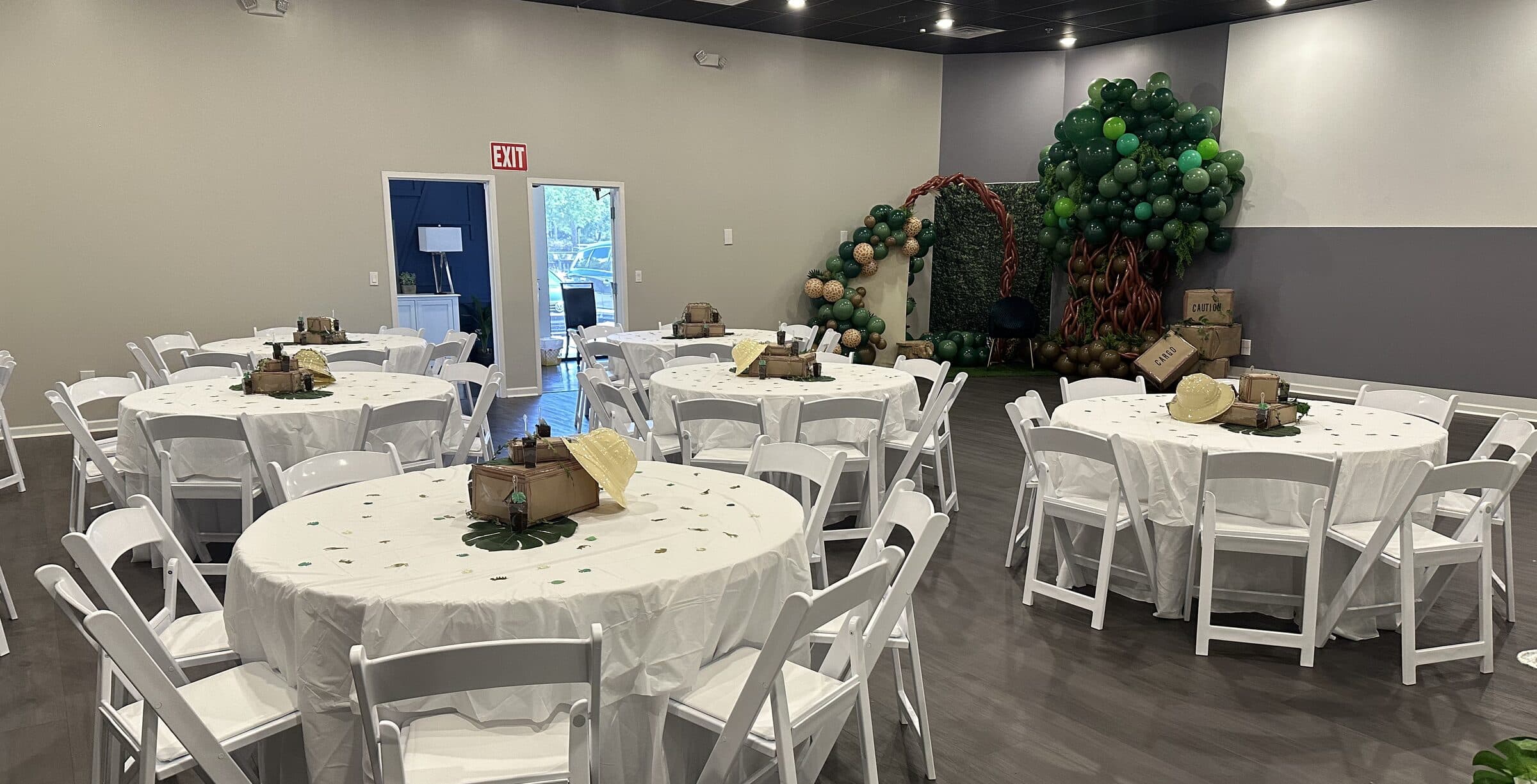Safari birthday floor plan with white rounds, cargo-crate centerpieces and explorer hats facing the green balloon tree at The Cove at St. Johns, St. Johns County FL